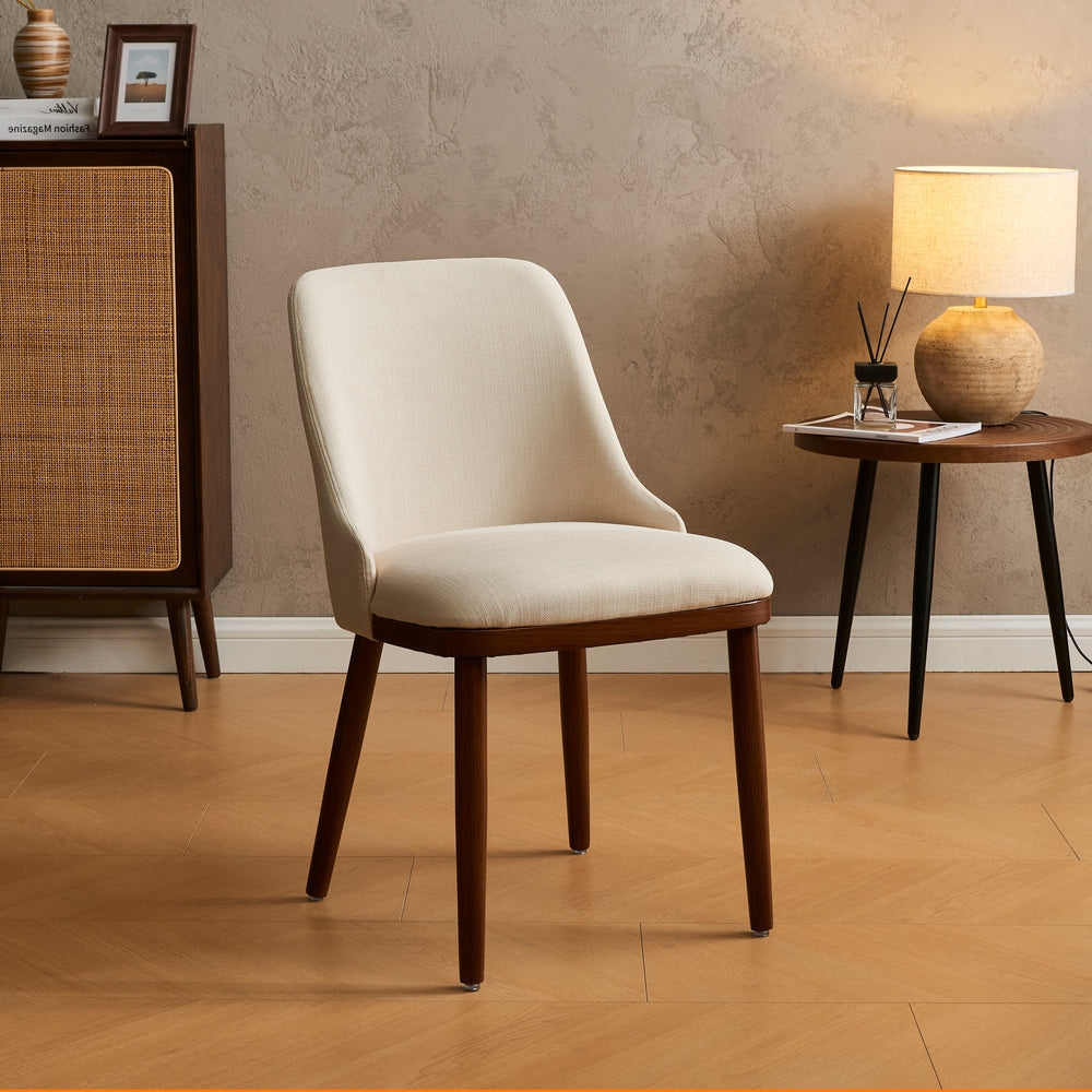 Modern Upholstered Dining Chair in cream fabric with walnut legs styled beside a rattan cabinet