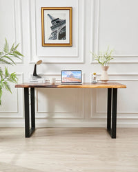 Live Edge Desk front view with black legs, laptop and decor against a paneled wall