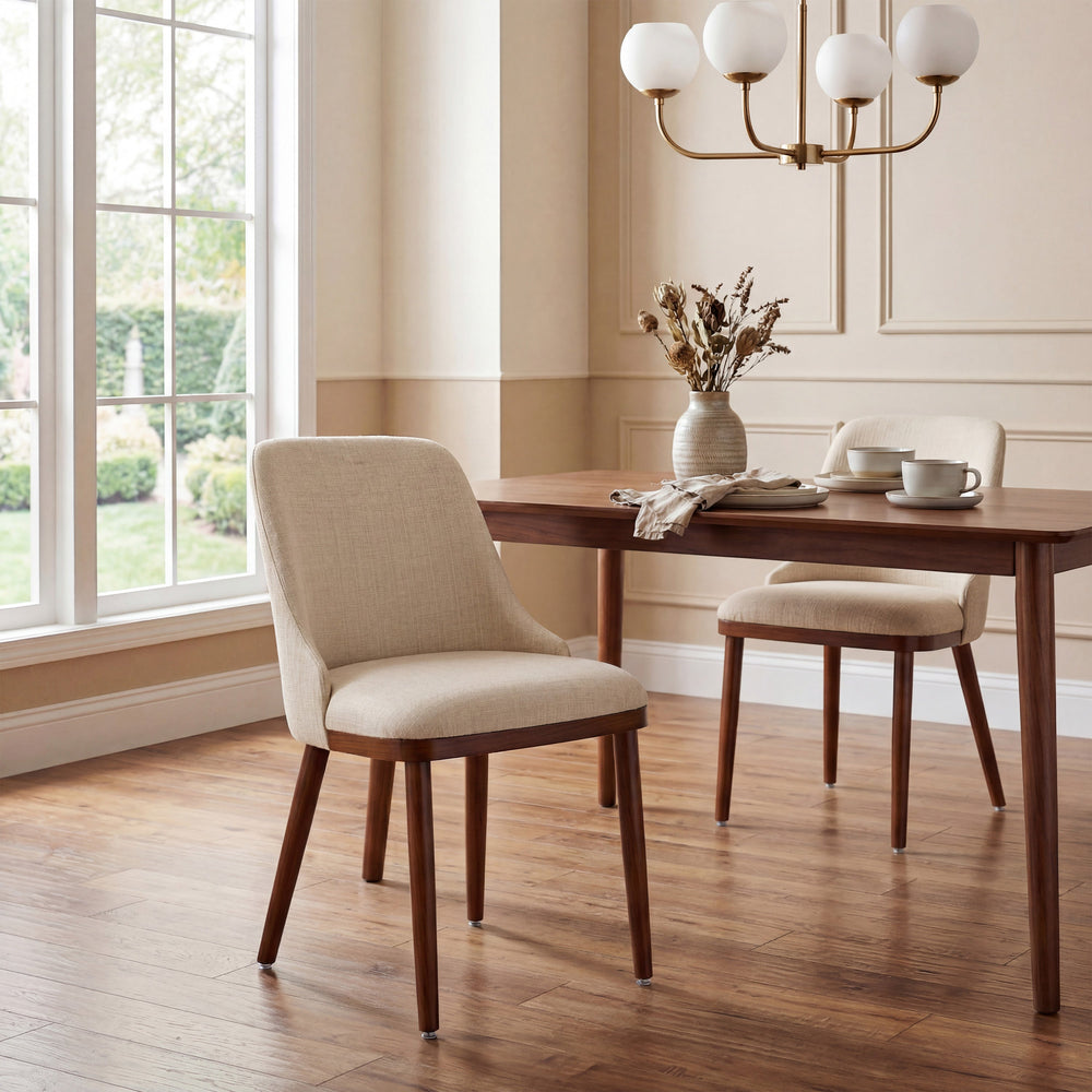 Two Modern Upholstered Dining Chairs in cream fabric at a walnut dining table in a bright room
