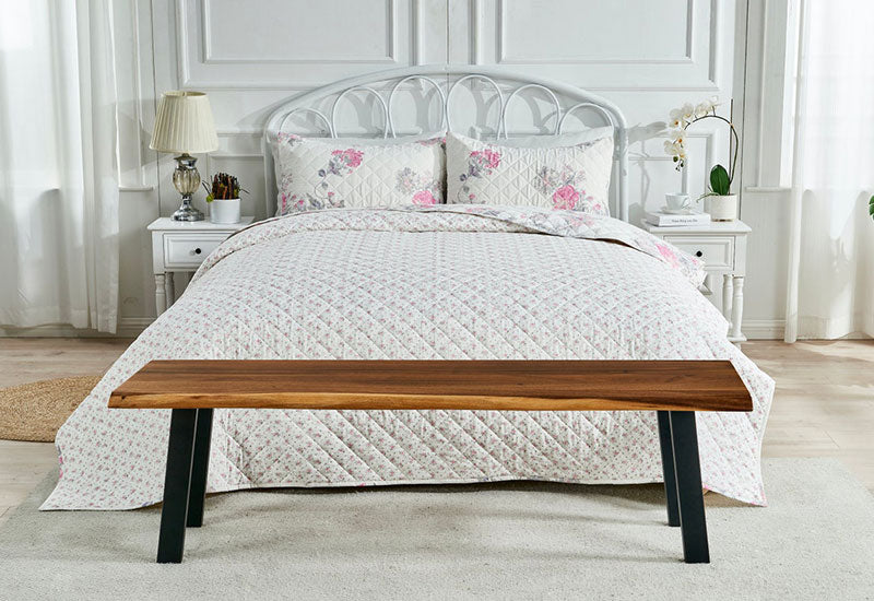 Live Edge Dining Bench placed at the end of a floral bed as a bedroom accent bench