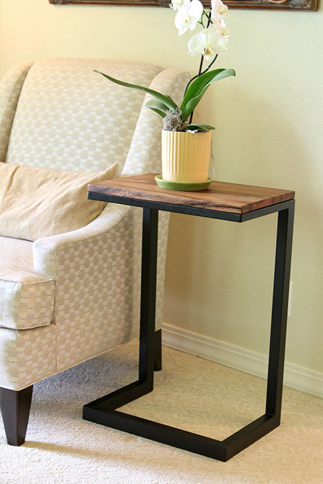 Modern Walnut C Table next to an armchair holding a yellow pot with a white orchid