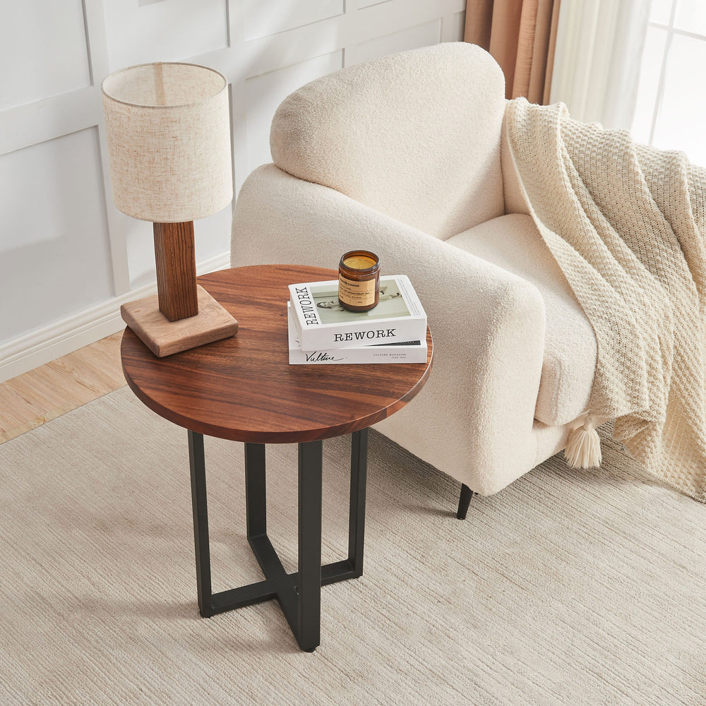 Overhead view of Round End Table walnut top with a lamp, candle and books by a boucle chair