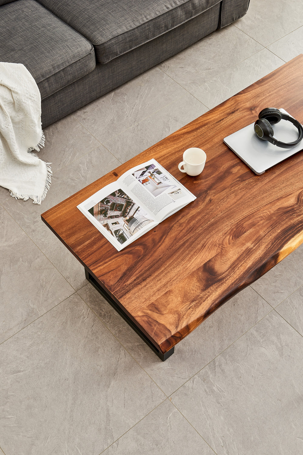 Overhead angled view of Live Edge Coffee Table walnut top beside a gray sofa