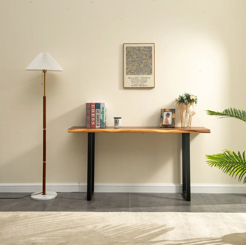 Live Edge Console Table with black legs holding books and decor against a beige wall