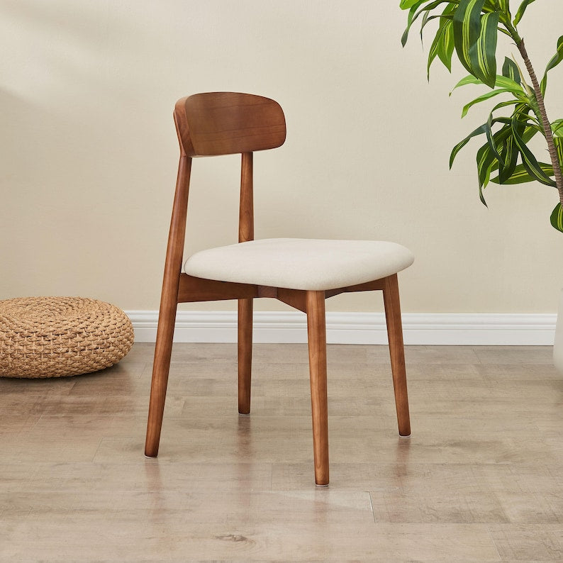 Modern Solid Wood Dining Chair in walnut with cream seat shown from the side by a plant