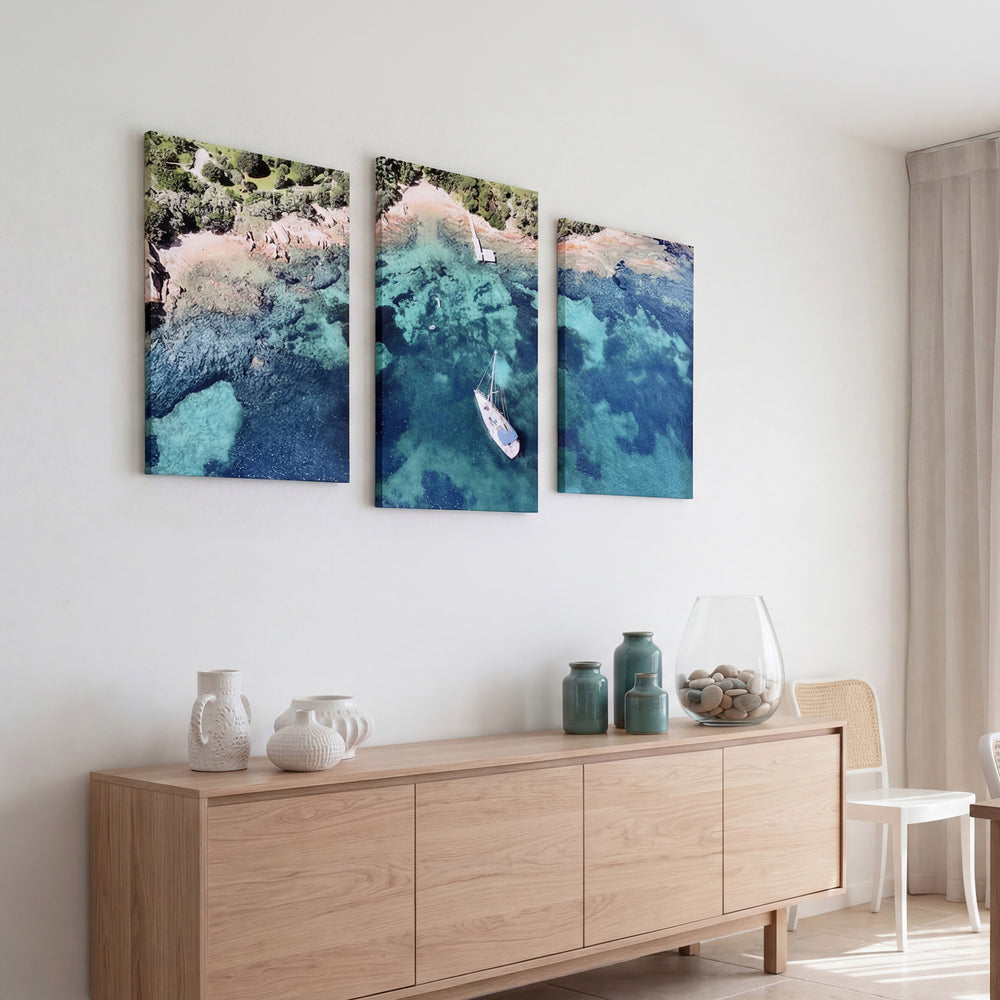 3-Panel Ocean canvas wall art above a light wood credenza with white and teal vases