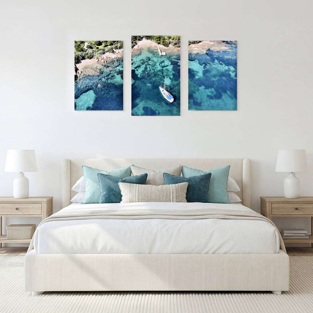 3-Panel Ocean canvas wall art displayed above a bed with teal accent pillows