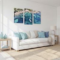 3-Panel Ocean canvas wall art above a white sofa in a sunlit living room