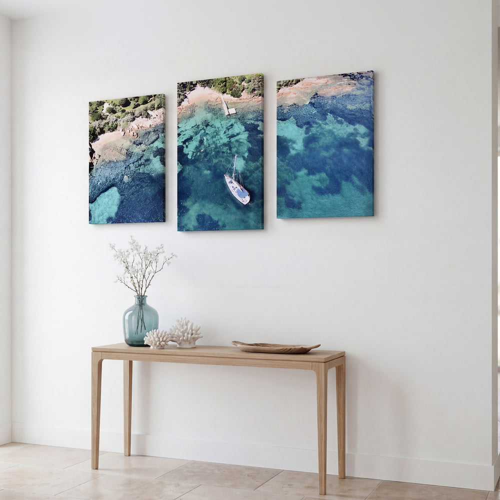 3-Panel Ocean canvas art angled on a wall above a console with flowers and coral