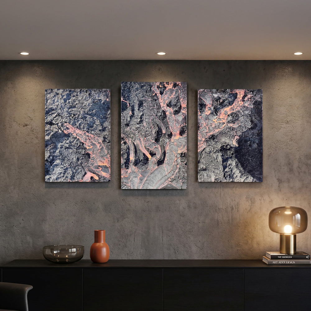 3-Panel Lava canvas wall art lit on a concrete wall above a black credenza with lamp