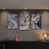3-Panel Lava canvas wall art lit on a concrete wall above a black credenza with lamp