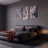 3-Panel Lava canvas wall art above a dark leather bed with rust throw in a moody bedroom