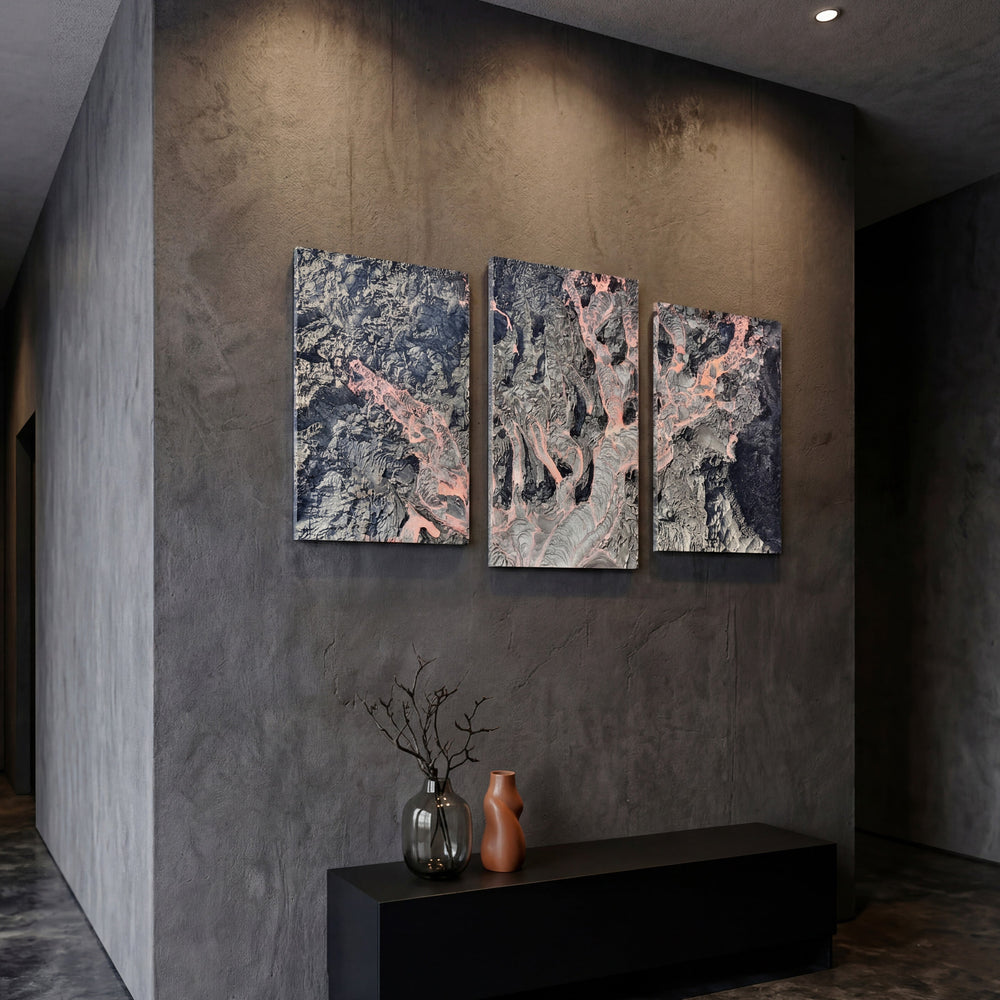 3-Panel Lava canvas art angled on a dark concrete wall above a black console with vases