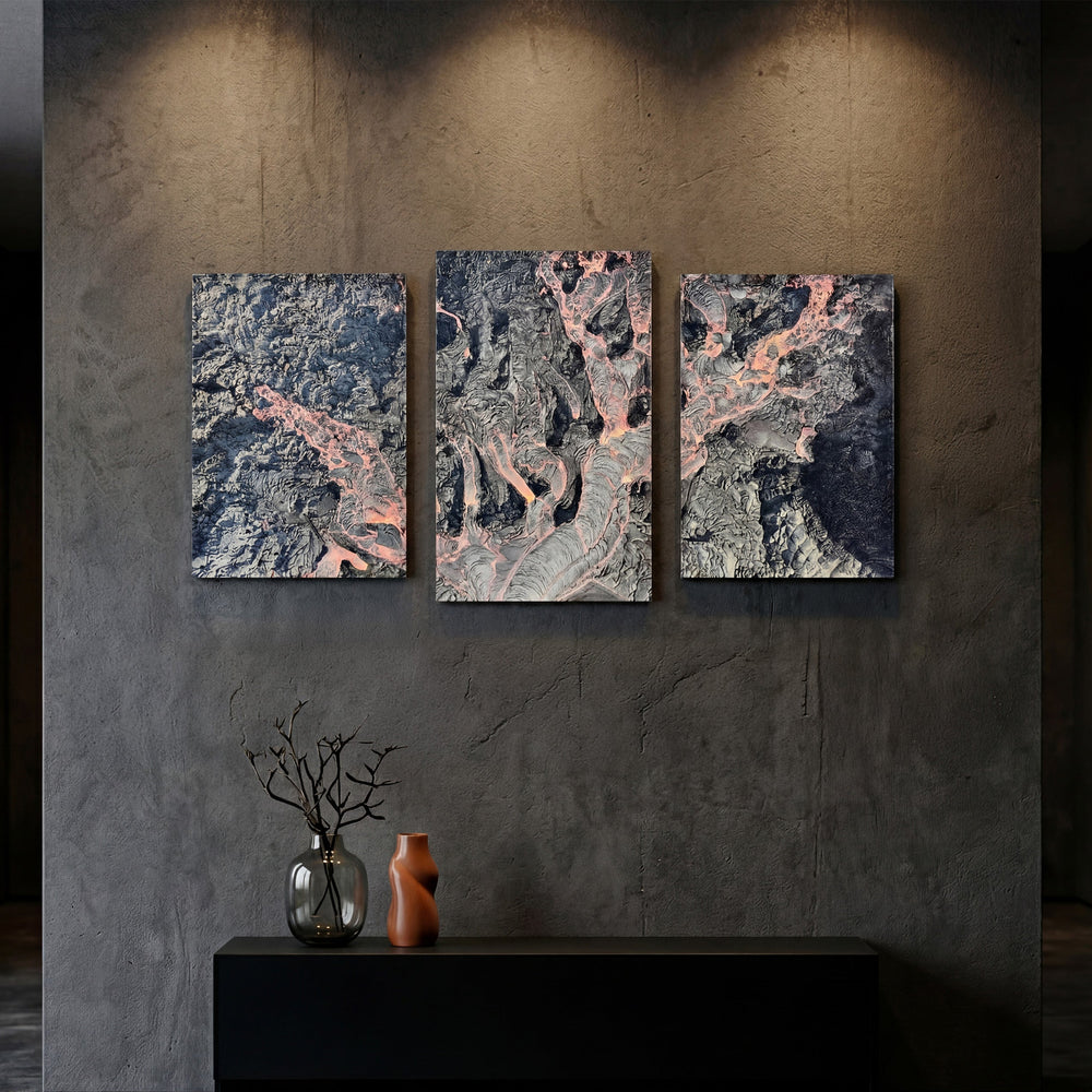 3-Panel Lava canvas wall art on a dark concrete wall above a black console with vases